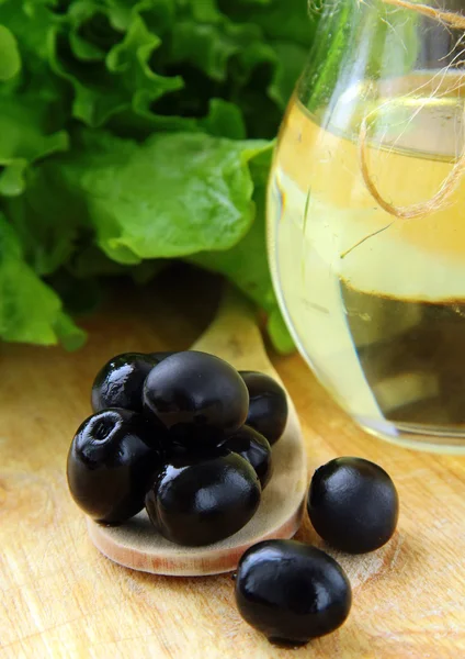Azeitonas pretas e uma garrafa de azeite — Fotografia de Stock