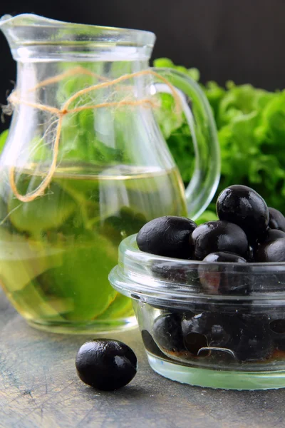 Zwarte olijven en een fles olijfolie — Stockfoto