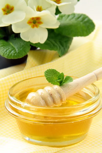 Miel fresca dorada en tarro con una cuchara de madera — Foto de Stock