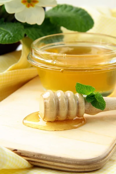 Miel fresca dorada en tarro con una cuchara de madera —  Fotos de Stock