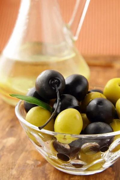 Azeitonas pretas e verdes e uma garrafa de azeite — Fotografia de Stock