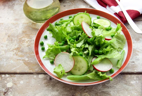 Salat med radiser, agurk, grønne ærter - Stock-foto