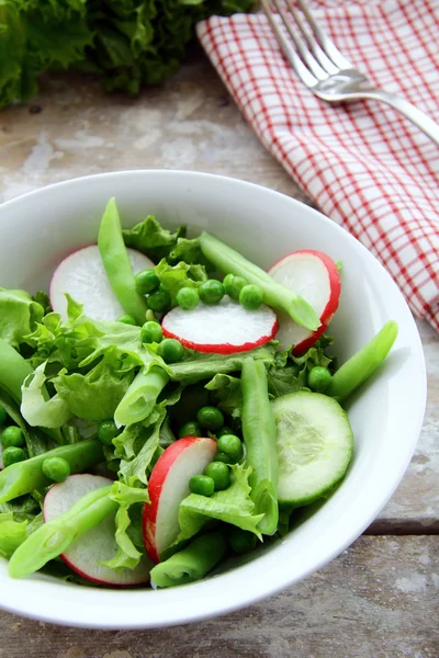 Salada com rabanetes, pepino, ervilhas verdes — Fotografia de Stock