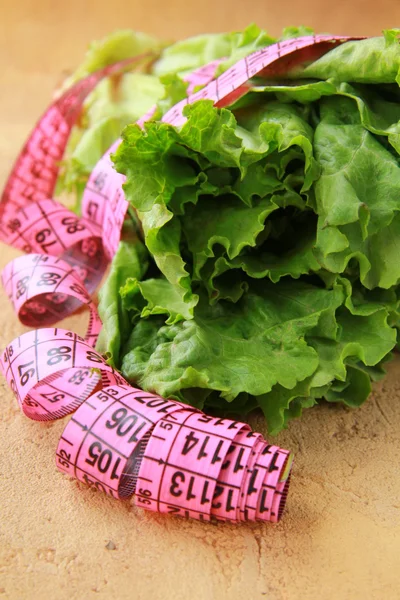 Green salad diet with a measuring tape — Stock Photo, Image