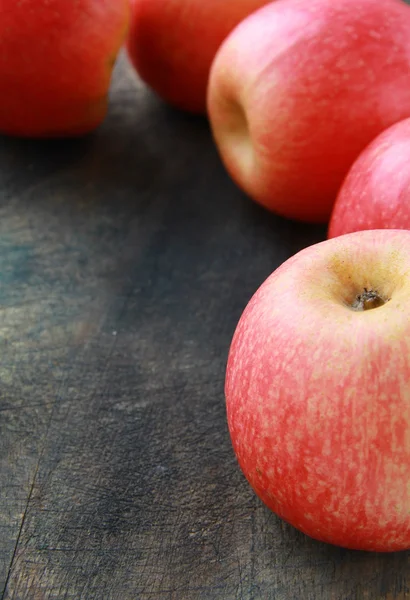 Красное яблоко на сером деревянном столе — стоковое фото
