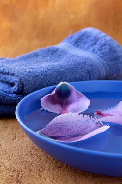 紫タオルと花の花びらのスパのコンセプト — ストック写真