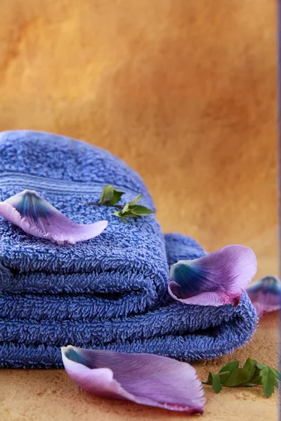 Serviettes violettes et pétales de fleurs concept de spa — Photo