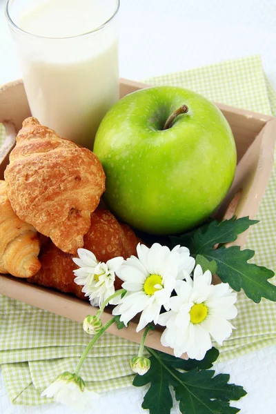 Desayuno cruasanes recién hechos, leche y una manzana verde —  Fotos de Stock