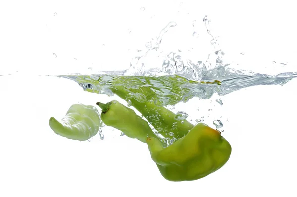 Green chilli thrown in water with — Stock Photo, Image