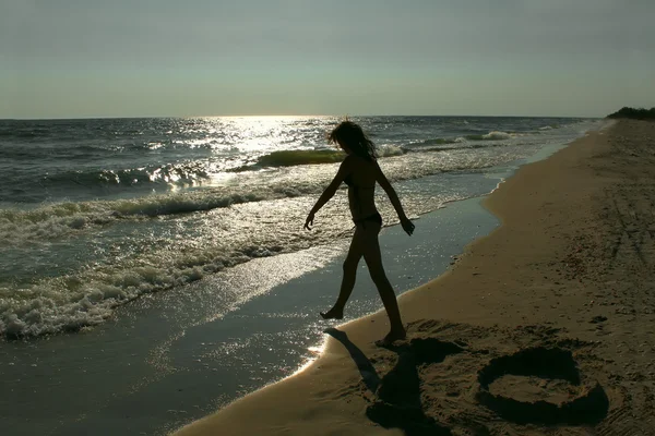 Silhouette of teenage girl on an empty beach — Stock Photo, Image