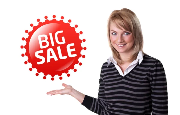 Jovem mulher de negócios feliz apresentando grande sinal de venda em sua mão — Fotografia de Stock