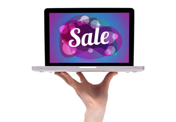 Una mano masculina sosteniendo un ordenador portátil con signo de venta —  Fotos de Stock