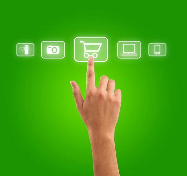 Hand pressing shopping cart symbol from media icons on green bac — Stock Photo, Image