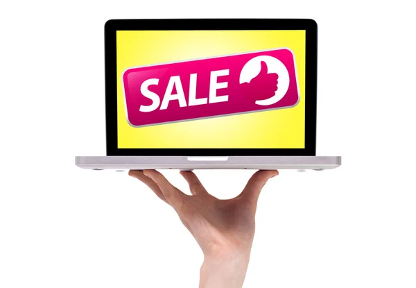 Męskiej ręki trzymającej laptopa z sprzedaży znak — Zdjęcie stockowe