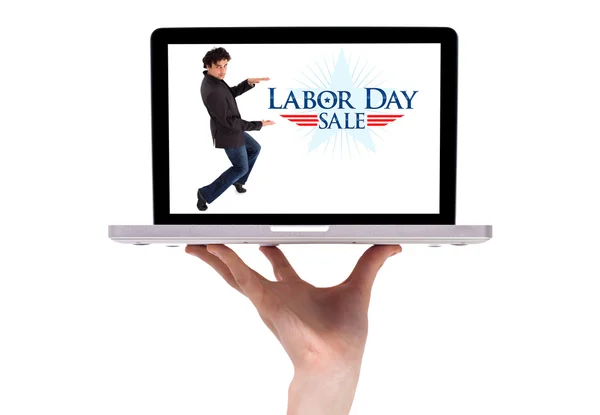 Une main masculine tenant un ordinateur portable avec un signe de la fête du travail — Photo