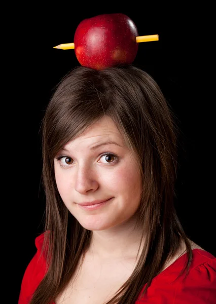 Mulher estudante bonita tem uma maçã com lápis na cabeça — Fotografia de Stock
