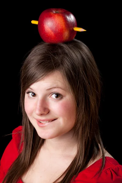 Vacker student kvinna har ett äpple med penna på huvudet — Stockfoto