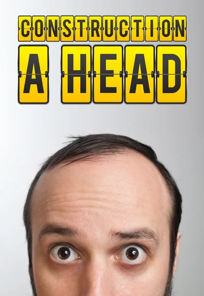 Άνθρωπος με σήμα "κατασκευή ένα κεφάλι" πάνω από το κεφάλι — Φωτογραφία Αρχείου