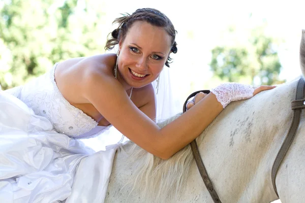 Atractiva mujer sonriente está sentada en el caballo — Foto de Stock