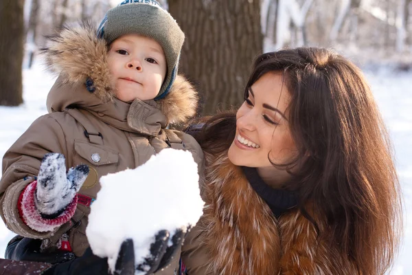 Mutter und Sohn vergnügen sich im Winterpark Stockbild
