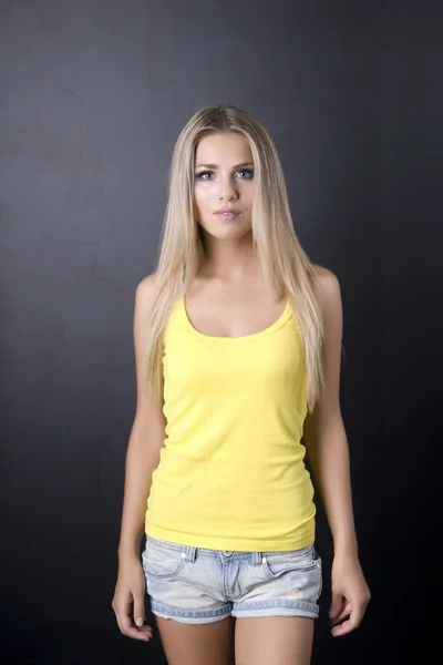 The girl in a yellow vest, on a black background, focus on eyes — Stock Photo, Image