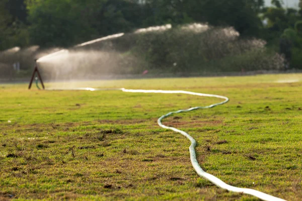 Acqua spruzzare campo di erba — Foto Stock