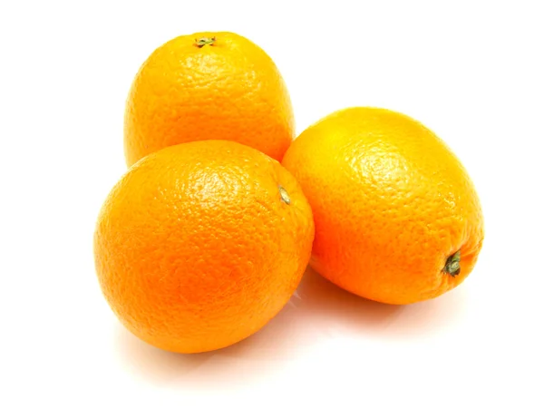 Tres naranjas maduras yacen cerca sobre un fondo blanco —  Fotos de Stock