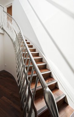 Modern designer staircase with interesting matt finish metal hand rail clipart