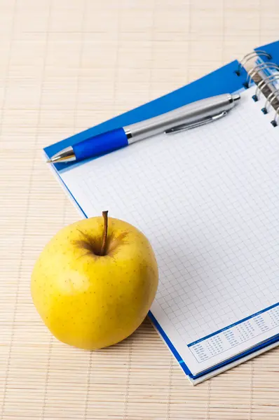 Откройте ноутбук, желтое яблоко и карандаш — стоковое фото
