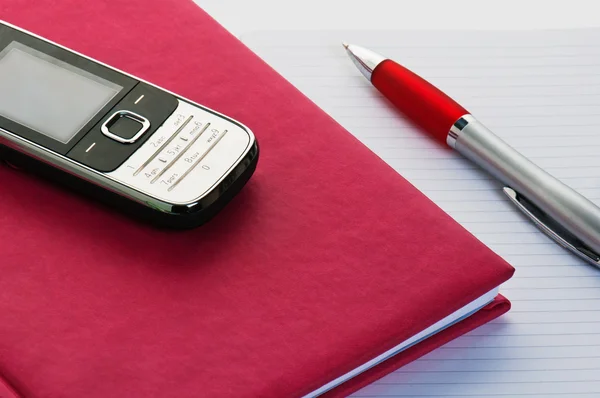 Telefone e lápis com um caderno. Um close-up — Fotografia de Stock