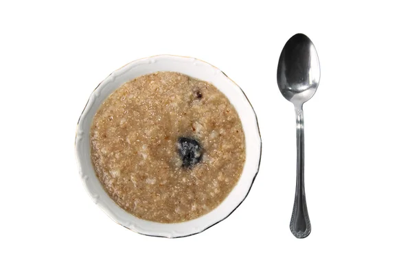 The spoon and a plate with a porridge — Stock Photo, Image