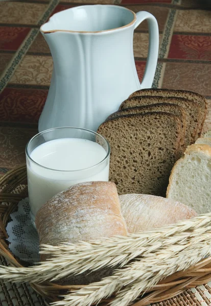 Ekmek ve bir bardak süt bir tabloda bir sepet içinde — Stok fotoğraf