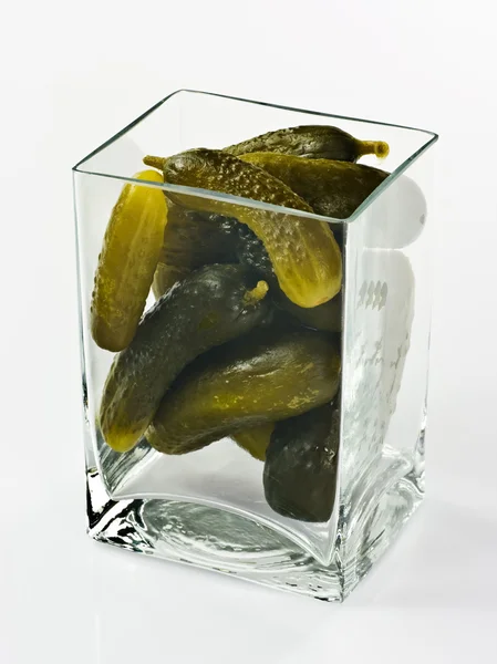 在白色背景上的玻璃容器中腌渍的黄瓜 — 图库照片