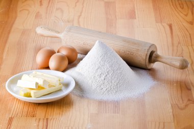 Flour with eggs, rolling pin and butter clipart