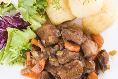 Stewed beef steak with potatoes and salad clipart