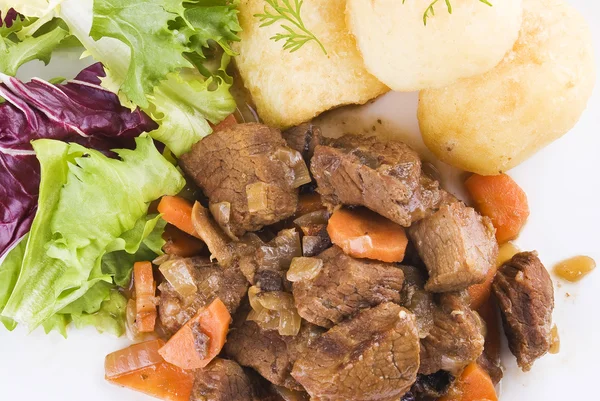 Stewed beef steak with potatoes and salad — Stock Photo, Image