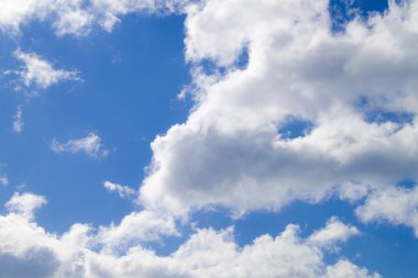 Cloudy skies. White cumulus clouds against a blue sky clipart