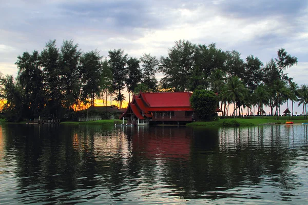 Bella vista tropicale: casa, lago, albero e tramonto — Foto Stock
