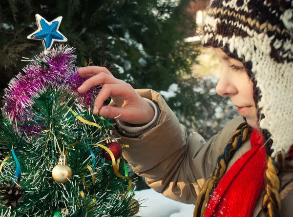 Dívka zdobí vánoční stromek — Stock fotografie