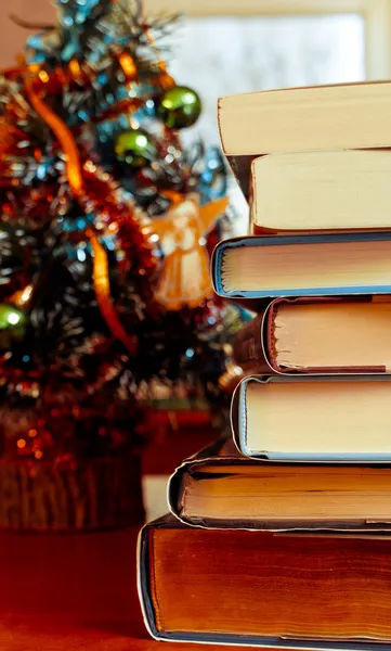 Books laying in front of Chrismas tree — Stock Photo, Image