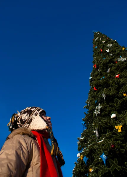 Mädchen schaut auf den Weihnachtsbaum — Stockfoto