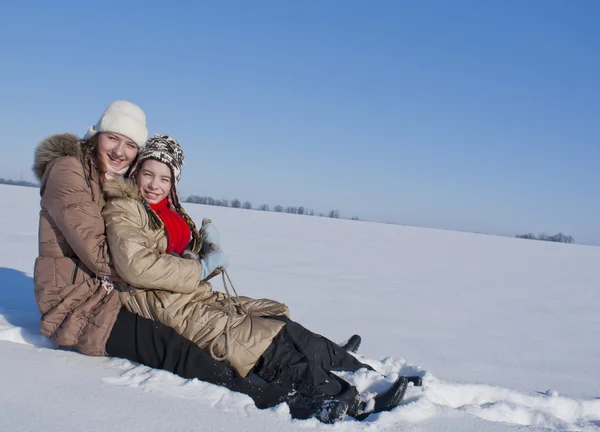 हिवाळ्याच्या वेळी दोन आनंदी बहिणींना स्लेडिंग — स्टॉक फोटो, इमेज