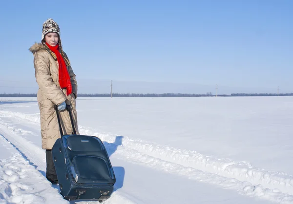 Dospívající dívka s kufrem venku v zimním období — Stock fotografie