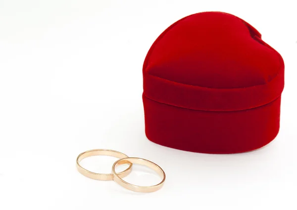 Два кольца и красная коробка в форме сердца — стоковое фото