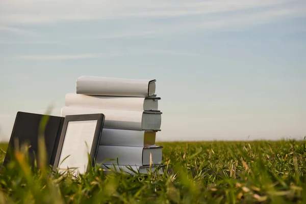 Stack di libri con lettore di ebook all'aperto posa su erba — Foto Stock