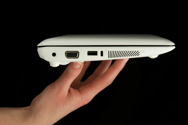 stock image Netbook held by fingers isolated on black