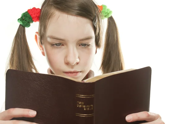 Menina adolescente lendo a Bíblia isolada no branco — Fotografia de Stock