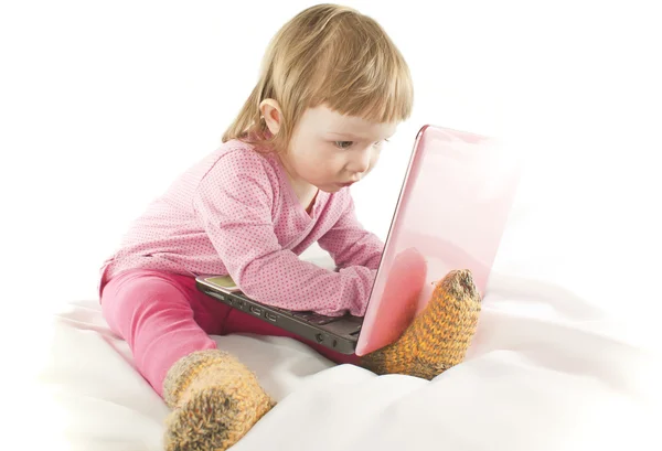 stock image Baby girl looking onto the laptop's screen on white background