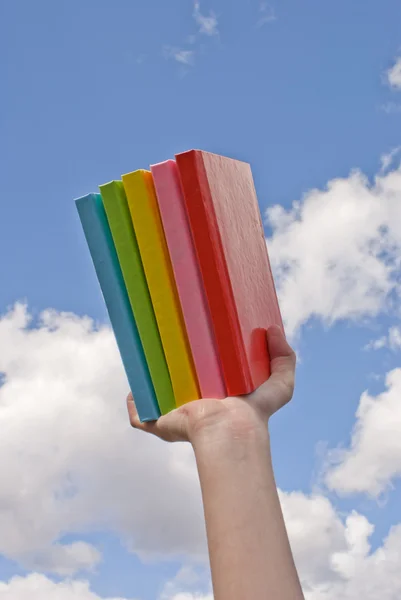 Mano sosteniendo libros de tapa dura de color —  Fotos de Stock