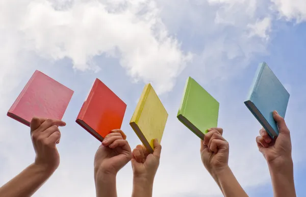 Руки держат цветные книги жесткой обложки — стоковое фото